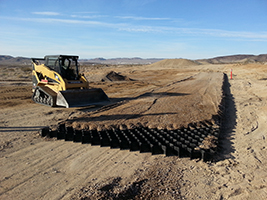 Track loader installing a cellular confinement system
